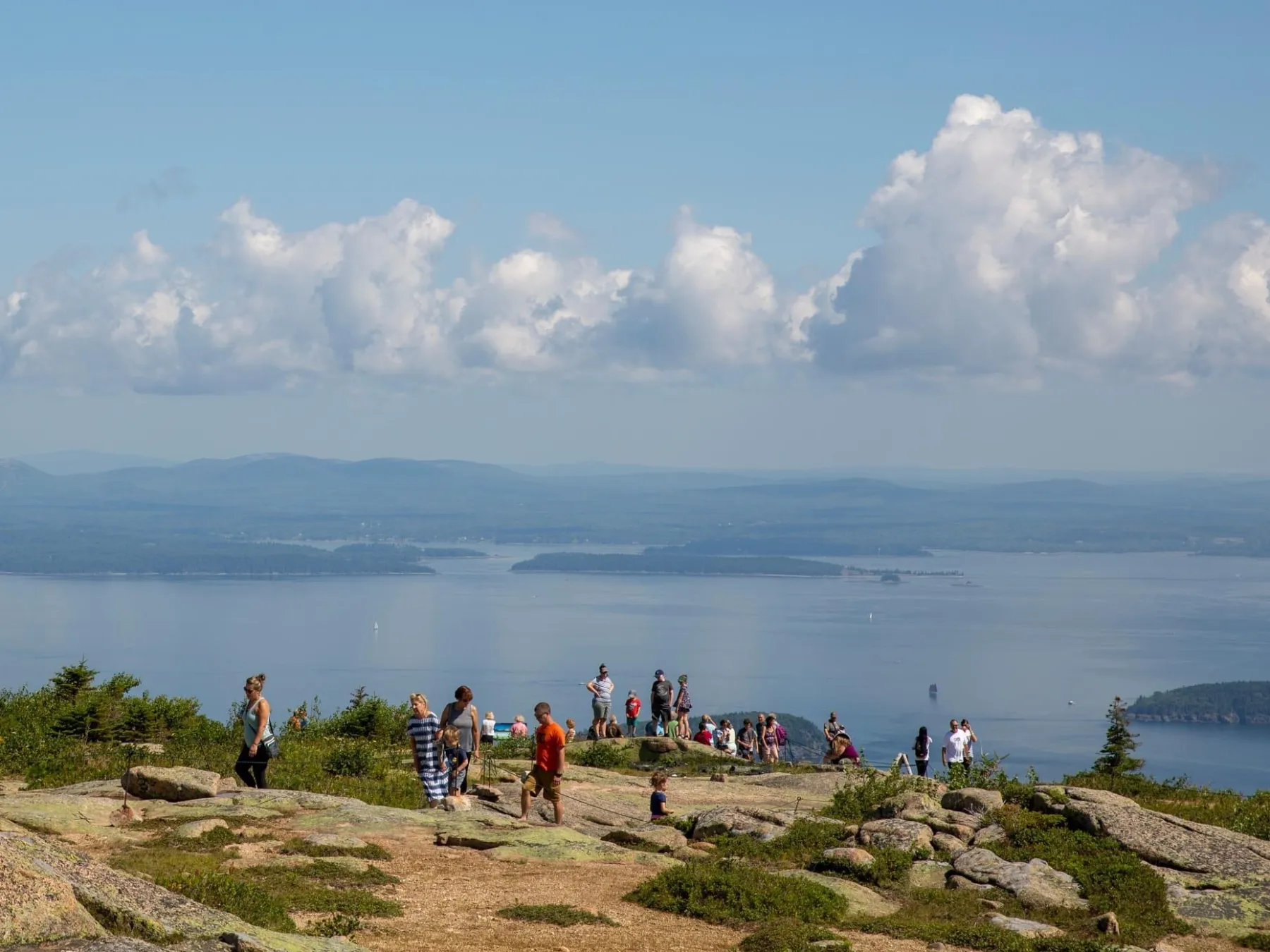 a group of people on a beach near a body of water