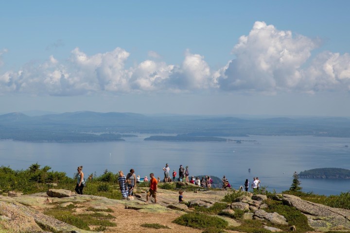 a group of people on a beach near a body of water