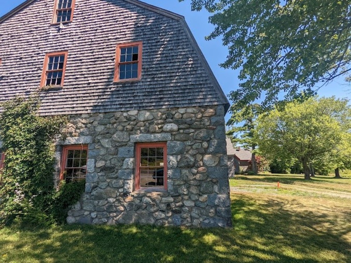 a large brick building with grass in front of a house